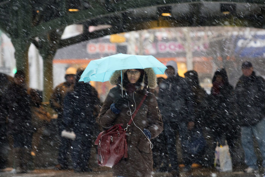 Commuters wait for a bus outside the Grove Street PATH station in Jersey City during a snowstorm on Monday, Jan. 26, 2015. Reena Rose Sibayan | The Jersey Journal