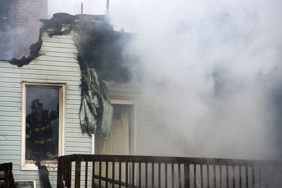 Firefighters battle a five-alarm blaze that ripped through two attached homes in Bayonne at 12 and 14 West 34th St. on Monday, Feb. 16, 2015. Reena Rose Sibayan | The Jersey Journal