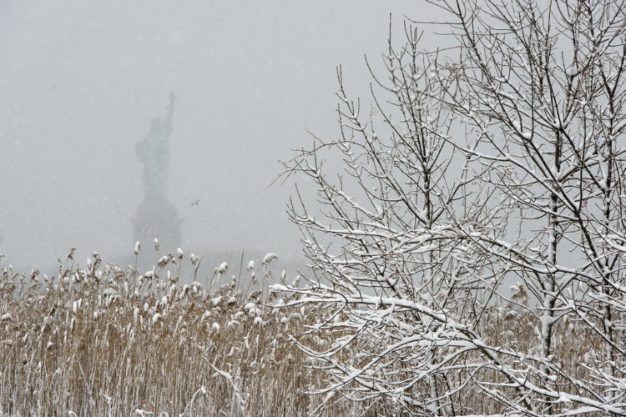 The Statue of Liberty is barely visible through snow falling at Liberty State Park in Jersey City during a winter storm on Thursday, March 5, 2015. Reena Rose Sibayan | The Jersey Journal