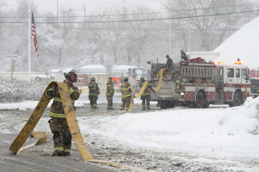 Jersey City Firefighter Wilfredo Rodriguez removes water from hoses to keep it from freezing inside as he and his fellow firefighters collect their gear after battling a two-alarm fire at Liberty Self-Storage, a facility at 302 Morris Pesin Drive inside Liberty State Park in Jersey City during a winter storm on Thursday, March 5, 2015. Reena Rose Sibayan | The Jersey Journal.
