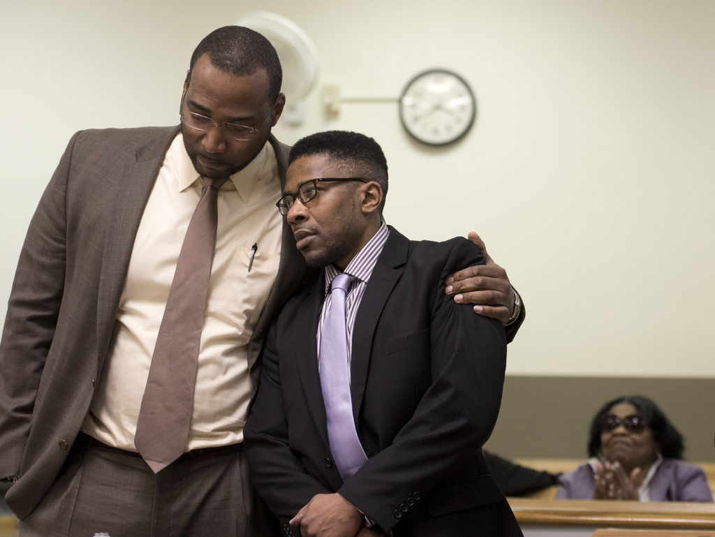 Defense attorney Mark Bailey, left, hugs Patrick Powell after the jury found his client not guilty of killing Robert Flagler on Thursday, March 31, 2016. Behind them, Powell's mother, Jackie, reacts to the verdict. Reena Rose Sibayan | The Jersey Journal