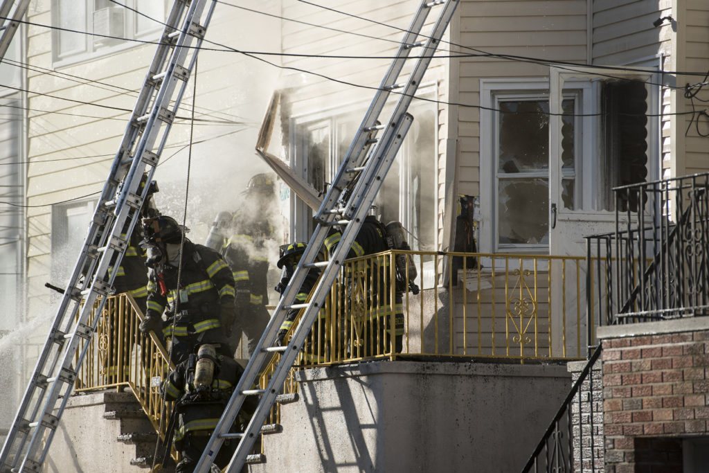 Firefighters battle a blaze at a West 26th Street home in Bayonne on Monday morning, April 18, 2016. Reena Rose Sibayan | The Jersey Journal