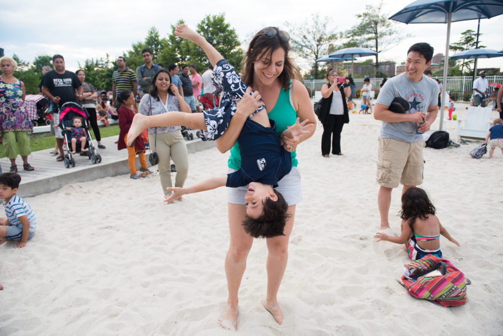 Residents young and old play in the beach with a view of the Manhattan skyline as they enjoy food from local restaurants and free live music performances during the 14th annual Newport Beach Party at Newport Green in Jersey City on Wednesday, July 13, 2016. Reena Rose Sibayan | The Jersey Journal