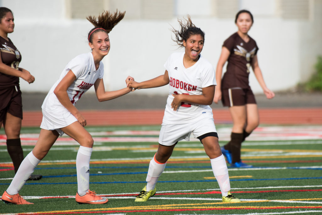 Hoboken defeats McNair, 1-0, in the girls soccer match at JFK Stadium in Hoboken on Tuesday, Sept. 20, 2016. Here, Hoboken's Elyse Santiago, right, celebrates with Zoe Higgins after scoring a goal in the first half. Reena Rose Sibayan | The Jersey Journal