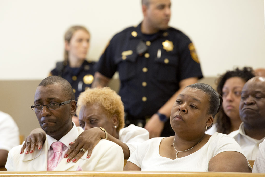 Ron Hill II's father, Ron Hill Sr., is comforted by his mother, Hattie Hill-Spry, as he listens with his wife, Pam Hill, to Superior Court Judge Joseph Isabella during the sentencing of Luis E. Garcia, 24, of the Bronx, on Friday, June 26, 2015. Reena Rose Sibayan | The Jersey Journal